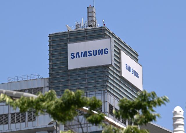 The logo of Samsung Electronics is seen on the top of a building at the company's headquarters in Suwon on May 22, 2026. Samsung labour union members will begin voting on May 22, on a tentative wage deal that could deliver hefty bonuses to chip workers and helped avert a major strike at the South Korean tech giant this week. (Photo by Jung Yeon-je / AFP)