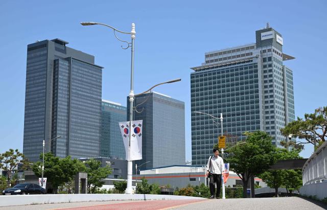 The logo (R top) of Samsung Electronics is seen on the top of a building at the company's headquarters in Suwon on May 22, 2026. Samsung labour union members will begin voting on May 22, on a tentative wage deal that could deliver hefty bonuses to chip workers and helped avert a major strike at the South Korean tech giant this week. (Photo by Jung Yeon-je / AFP)