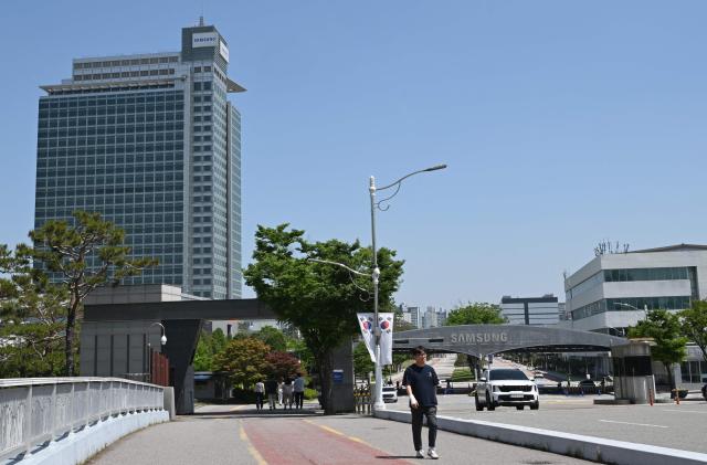 The logo of Samsung Electronics is seen on a gate at the company's headquarters in Suwon on May 22, 2026. Samsung labour union members will begin voting on May 22, on a tentative wage deal that could deliver hefty bonuses to chip workers and helped avert a major strike at the South Korean tech giant this week. (Photo by Jung Yeon-je / AFP)