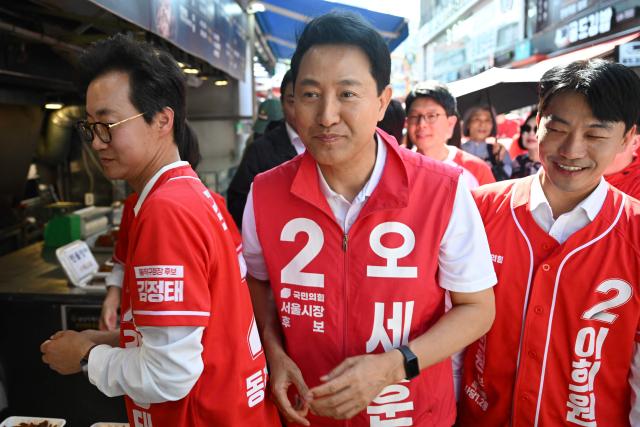 Mayoral candidate Oh Se-hoon (C) of the People Power Party arrives to a political rally ahead of the upcoming local elections in Seoul on May 22, 2026. (Photo by Pedro PARDO / AFP)