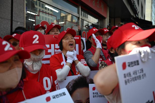 Supporters of mayoral candidate Oh Se-hoon of the People Power Party hold placards as they attend a political rally ahead of the upcoming local elections in Seoul on May 22, 2026. (Photo by Pedro PARDO / AFP)