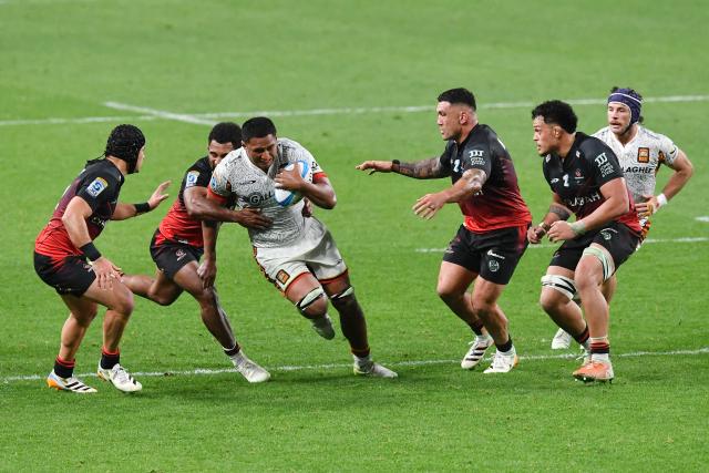 Chiefs' Samipeni Finau (C) is tackled during the Super Rugby Pacific match between the Crusaders and Chiefs at One New Zealand Stadium in Christchurch on May 22, 2026. (Photo by Sanka Vidanagama / AFP)