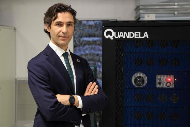 CEO of Quandela Niccolo Somaschi poses during a photo session next to a Quandela photonic quantum computer as part of a visit of France's President to the European Forum on Computing Power, Quantum Sciences and Technologies, and Semiconductors at the Very Large Computing Centre of the French Alternative Energies and Atomic Energy Commission (CEA) in Bruyeres-le-Chatel, south of Paris on May 22, 2026. (Photo by Ludovic MARIN / POOL / AFP)