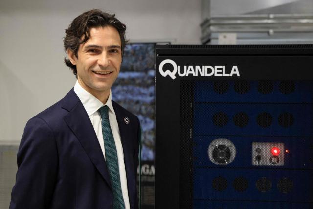 CEO of Quandela Niccolo Somaschi poses during a photo session next to a Quandela photonic quantum computer as part of a visit of France's President to the European Forum on Computing Power, Quantum Sciences and Technologies, and Semiconductors at the Very Large Computing Centre of the French Alternative Energies and Atomic Energy Commission (CEA) in Bruyeres-le-Chatel, south of Paris on May 22, 2026. (Photo by Ludovic MARIN / POOL / AFP)