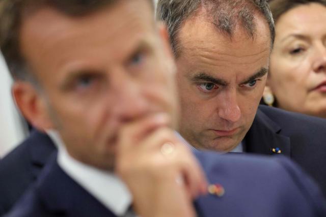 France's Prime Minister Sebastien Lecornu (R) looks on as France's President Emmanuel Macron listens during a visit to the European Forum on Computing Power, Quantum Sciences and Technologies, and Semiconductors at the Very Large Computing Centre of the French Alternative Energies and Atomic Energy Commission (CEA) in Bruyeres-le-Chatel, south of Paris on May 22, 2026. (Photo by Ludovic MARIN / POOL / AFP)