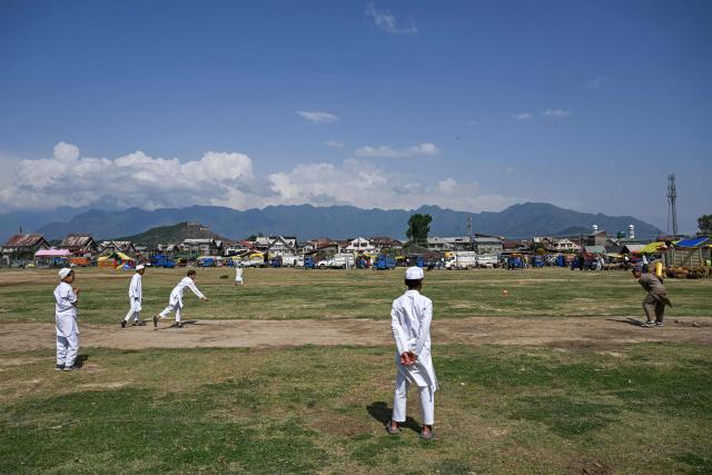 Children play cricket on a ground in Srinagar on May 22, 2026. (Photo by Tauseef MUSTAFA / AFP)