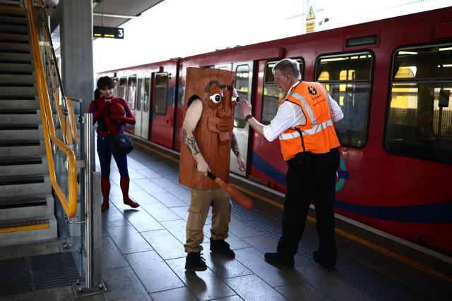 A cosplayer speaks with an official after leaving the train, as they arrive for the MCM Comic Con at ExCeL exhibition centre in London on May 22, 2026. (Photo by Henry NICHOLLS / AFP)