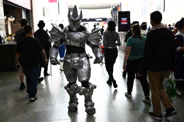 Cosplayers mingle with members of the public during the MCM Comic Con at ExCeL exhibition centre in London on May 22, 2026. (Photo by Henry NICHOLLS / AFP)