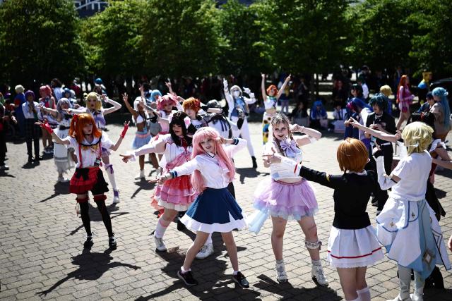 Cosplayers dance outside the venue of the MCM Comic Con at ExCeL exhibition centre in London on May 22, 2026. (Photo by Henry NICHOLLS / AFP)