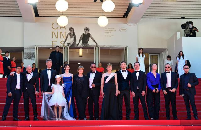 (From L) Bulgarian actor Syuleyman Alilov Letifov (3rdL), German film director Valeska Grisebach (C-L), Bulgarian actress Yana Radeva (6thR) and German producer Jonas Dornbach (4thR) arrive with cast members for the screening of the film "Das Getraumte Abenteuer" (The Dreamed Adventure) at the 79th edition of the Cannes Film Festival in Cannes, southern France on May 22, 2026. (Photo by Olivier CHASSIGNOLE / AFP)