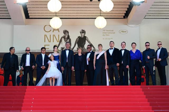 Bulgarian actor Syuleyman Alilov Letifov (6thL), German film director Valeska Grisebach (C), Bulgarian actress Yana Radeva (6thR), German producer Jonas Dornbach (4thR) arrive with cast members for the screening of the film "Das Getraumte Abenteuer" (The Dreamed Adventure) at the 79th edition of the Cannes Film Festival in Cannes, southern France on May 22, 2026. (Photo by Olivier CHASSIGNOLE / AFP)