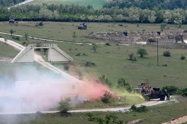 Soldiers take part in the joint "NATO–Serbia" military exercise at a training ground near Bujanovac in southern Serbia on May 22, 2026, during the first military drills conducted directly between Serbia and NATO. Around 600 troops from Serbia, Italy, Romania and Turkey participated in the exercise under NATO’s Partnership for Peace programme, which Belgrade says respects the country’s policy of military neutrality. The drills mark a rare public military cooperation between Serbia and the Alliance, whose 1999 bombing campaign during the Kosovo war remains a sensitive subject in the Balkan country. (Photo by Sasa Djordjevic / AFP)