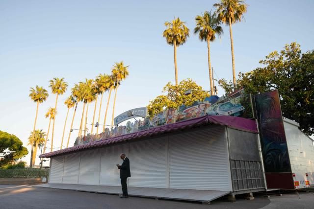 A festival-goer in evening attire stands on the Boulevard de la Croisette during the 79th edition of the Cannes Film Festival in Cannes, southern France, on May 22, 2026. (Photo by Anna KURTH / AFP)