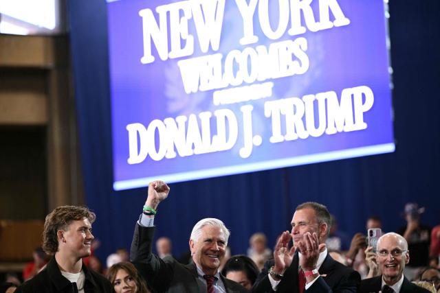 New York Giants quarterback Jaxson Dart (L) stands next to Bruce Blakemen, who is running for governor of New York, as the US president speaks about the economy at Rockland Community College Fieldhouse in Suffern, New York, on May 22, 2026. Trump is the first sitting president to visit the northern New York City suburbs since Gerald Ford in 1976. (Photo by Brendan SMIALOWSKI / AFP)