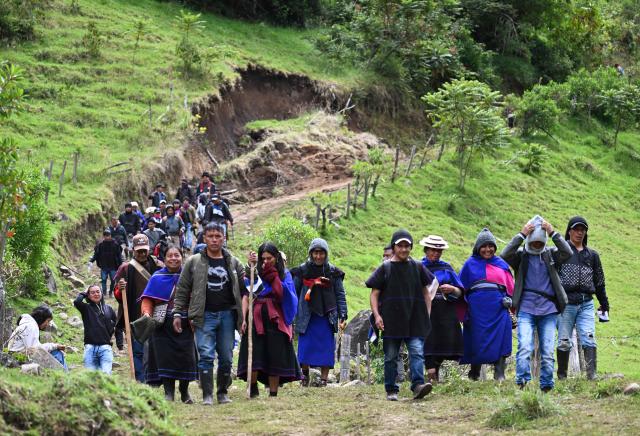 Misak indigenous people walk on a road at the Guambia reserve near Silvia, Cauca department, Colombia on May 22, 2026. A land dispute between two indigenous groups left six people dead and 65 injured in a troubled region of Colombia on May 22, 2026, according to local authorities. (Photo by JOAQUIN SARMIENTO / AFP)