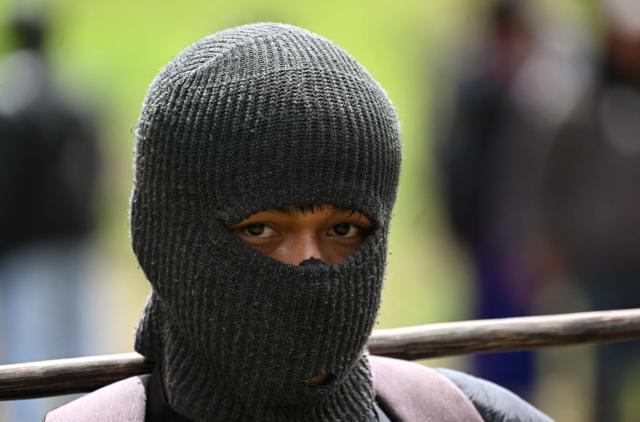 A Misak indigenous man uses a balaclava at the Guambia reserve near Silvia, Cauca department, Colombia on May 22, 2026. A land dispute between two indigenous groups left six people dead and 65 injured in a troubled region of Colombia on May 22, 2026, according to local authorities. (Photo by JOAQUIN SARMIENTO / AFP)