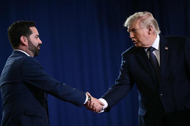US President Donald Trump shakes hands with Representative Mike Lawler while speaking about the economy at Rockland Community College Fieldhouse in Suffern, New York, on May 22, 2026. Trump is the first sitting president to visit the northern New York City suburb since Gerald Ford in 1976. (Photo by Brendan SMIALOWSKI / AFP)