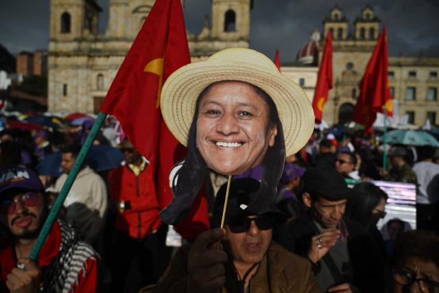 A supporter holds a placard depicting the images of Colombia's vice presidential candidate Aida Quilcue for the Pacto Historico party ahead of the start of a campaign rally at Plaza Bolivar in Bogota on May 22, 2026. Colombia will hold presidential elections on May 31. (Photo by Raul ARBOLEDA / AFP)
