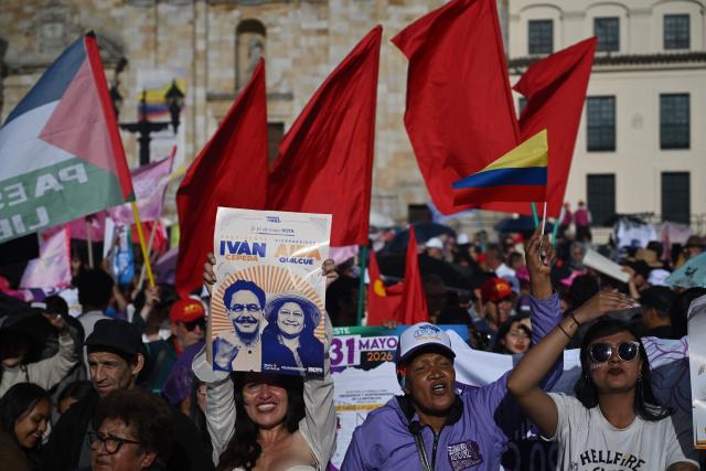 A supporter holds a placard depicting the images of Colombia's presidential candidate Ivan Cepeda and his running mate Aida Quilcue for the Pacto Historico party ahead of the start of a campaign rally at Plaza Bolivar in Bogota on May 22, 2026. Colombia will hold presidential elections on May 31. (Photo by Raul ARBOLEDA / AFP)