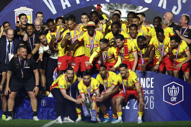 (From Bottom L) Lens' French defender #24 Jonathan Gradit, Lens' French midfielder #28 Adrien Thomasson, Lens' French forward #22 Wesley Said and Lens' French forward #07 Florian Sotoca celebrate with the trophy and teammates after winning the French Cup final football match between RC Lens and OGC Nice at the Stade de France stadium, in Saint-Denis, on the outskirts of Paris, on May 22, 2026. (Photo by FRANCK FIFE / AFP)