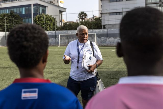 Silveria Nedio “Nita”, historic manager of the Cape Verde women's national football team and director of the Bola Pra Frente football academy, talks to football students during practice in Praia, on May 22, 2026. Bola Pra Frente is considered one of the most renowned football academies in Cape Verde, with former students Joao Paulo Fernandes and Kevin Pina being part of the national team set to compete at the World Cup 2026. Bola Pra Frente is considered one of the most renowned football academies in Cape Verde, with former students Joao Paulo Fernandes and Kevin Pina being part of the national team set to compete at the World Cup 2026. (Photo by PATRICK MEINHARDT / AFP)
