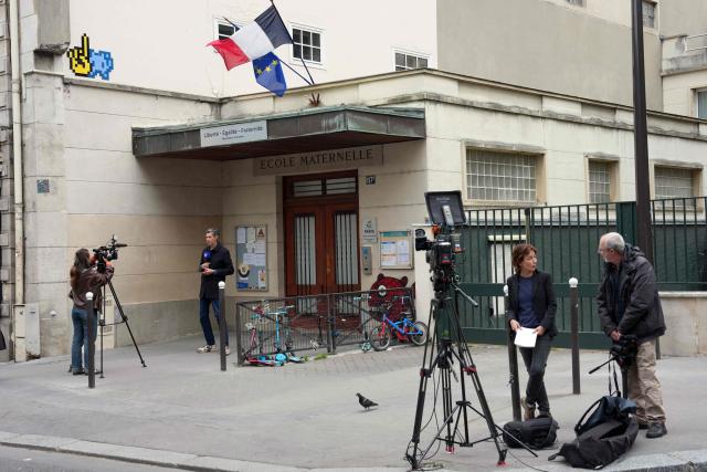 (FILES) Journalists film outside the Saint-Dominique school in Paris on May 20, 2026, after sixteen people from the school were taken into police custody . Two teachers, aged 52 and 44 respectively, who worked at the Saint-Dominique school in Paris, were charged and remanded in custody on May 22, 2026 evening on suspicion of sexual assault, AFP has learnt from judicial sources and those close to the case. (Photo by Dimitar DILKOFF / AFP)