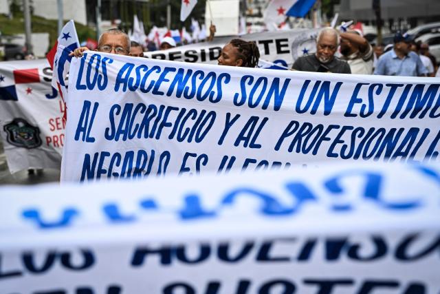 Demonstrators hold banners as they take part in a march in protest called by workers and members of social organizations against the government of Panamanian President Jose Raul Mulino in Panama City on May 22, 2026. (Photo by MARTIN BERNETTI / AFP)