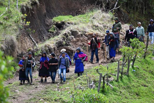 Misak indigenous people walk on a road at the Guambia reserve near Silvia, Cauca department, Colombia on May 22, 2026. A land dispute between two indigenous groups left six people dead and 65 injured in a troubled region of Colombia on May 22, 2026, according to local authorities. (Photo by JOAQUIN SARMIENTO / AFP)