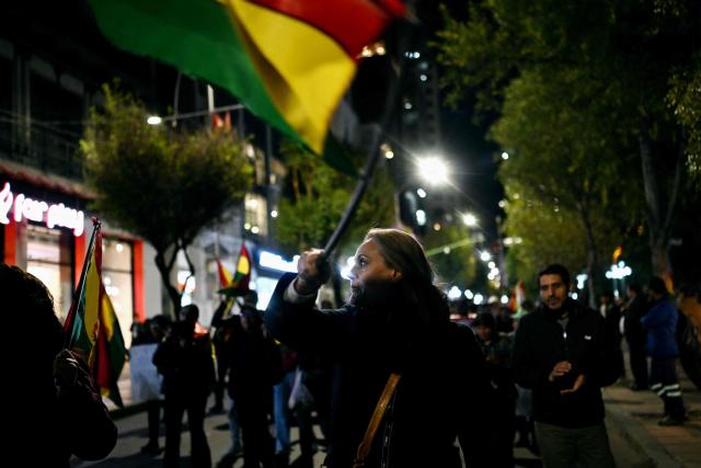 A supporters of the government waves a national flag during a demonstration in favor of President Rodrigo Paz and against the blockades in La Paz on May 22, 2026. Thousands of protesters gathered in Bolivia’s political capital on May 22 to demand the resignation of center-right President Rodrigo Paz, during another day of protests that led to clashes with riot police. (Photo by MARVIN RECINOS / AFP)