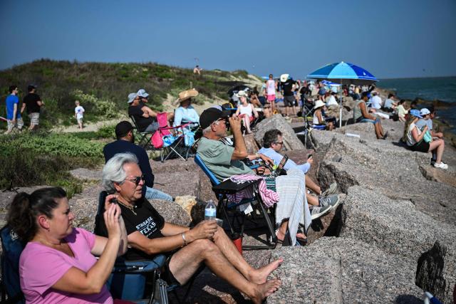 People watch the launch of SpaceX's Starship 39 rocket from Starbase as they gather in South Padre Island, Texas, on May 22, 2026. Elon Musk's SpaceX on May 22 launched its latest Starship, sending the mammoth rocket soaring into the Texas skies after its initial attempt was scrubbed due to technical issues. The Starship spacecraft and Super Heavy rocket booster appeared to separate as expected, but the company's spokesperson Dan Huot said on the livestream that the booster did not complete a burn necessary to steer itself to a controlled landing, meaning it likely can't make a precision touchdown as hoped. (Photo by RONALDO SCHEMIDT / AFP)