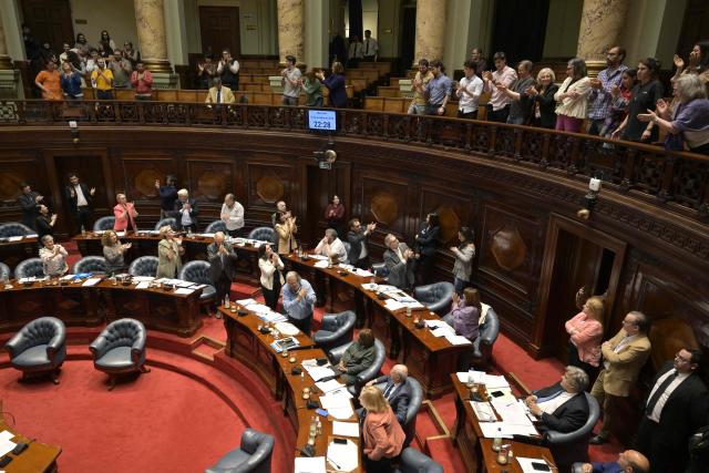 (FILES) Senators who votes in favour of a euthanasia bill and advocates, celebrate after its approval at the Legislative Palace in Montevideo on October 15, 2025. A cancer patient became the first person to die by euthanasia in Uruguay on May 22, 2026, a country that passed a pioneering law in Latin America last year, a source from the Medical Association confirmed to AFP. (Photo by Santiago Mazzarovich / AFP)