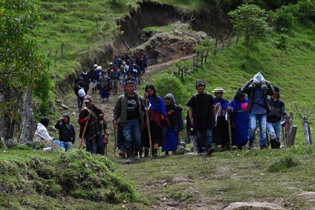 Misak indigenous people walk on a road at the Guambia reserve near Silvia, Cauca department, Colombia on May 22, 2026. A land dispute between two indigenous groups left six people dead and 65 injured in a troubled region of Colombia on May 22, 2026, according to local authorities. (Photo by JOAQUIN SARMIENTO / AFP)