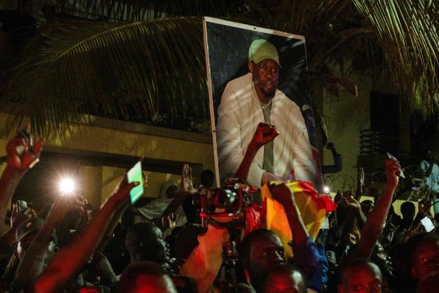 Supporters carry a photo of Ousmane Sonko as they protest outside his home in Dakar on May 23, 2026 following his dismissal as Senegal's prime minister. Senegal President Bassirou Diomaye Faye on May 22 sacked Prime Minister Ousmane Sonko and dissolved the government after months of tensions, deepening a crisis in the debt-laden west African nation. The shock announcement was made on state television in a decree read out by presidential aide Oumar Samba Ba, who said Faye "has ended the duties of Ousmane Sonko...  and consequently those of the ministers and secretaries of state who are members of the government". (Photo by SEYLLOU / AFP)