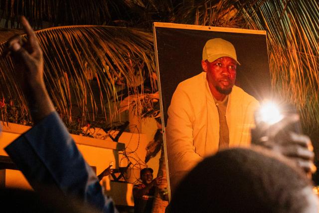 Supporters carry a photo of Ousmane Sonko as they protest outside his home in Dakar on May 23, 2026 following his dismissal as Senegal's prime minister. Senegal President Bassirou Diomaye Faye on May 22 sacked Prime Minister Ousmane Sonko and dissolved the government after months of tensions, deepening a crisis in the debt-laden west African nation. The shock announcement was made on state television in a decree read out by presidential aide Oumar Samba Ba, who said Faye "has ended the duties of Ousmane Sonko...  and consequently those of the ministers and secretaries of state who are members of the government". (Photo by SEYLLOU / AFP)