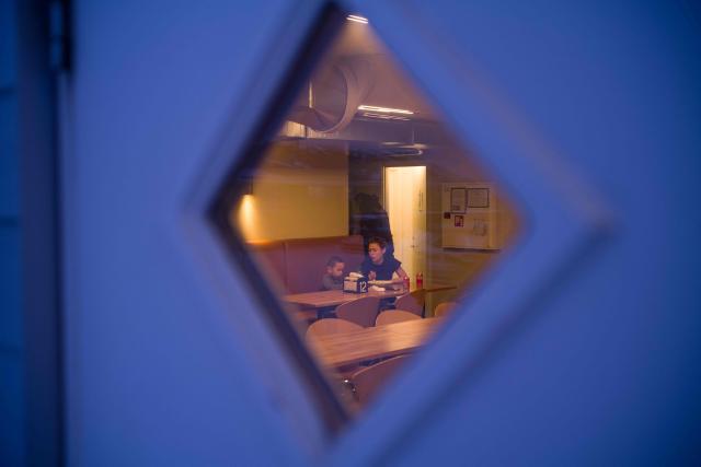 A family is sitting at a table in the Nuka cafй, where many Asian workers are employed, in Ilulissat, Greenland, on March 19, 2026. Around 1,200 Filipinos are settled in Greenland, which has 57,000 inhabitants, making them the largest foreign diaspora in this Danish territory. According to Greenland’s employers’ organisations, 5 to 6% of workers in the Arctic territory are now Asian, drawn by expanding sectors such as tourism. (Photo by Florent VERGNES / AFP)