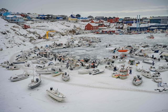 This photograph shows the snow-covered harbour, where many fishermen from the Philippines work, in Ilulissat, Greenland, on March 18, 2026. Around 1,200 Filipinos are settled in Greenland, which has 57,000 inhabitants, making them the largest foreign diaspora in this Danish territory. According to Greenland’s employers’ organisations, 5 to 6% of workers in the Arctic territory are now Asian, drawn by expanding sectors such as tourism. (Photo by Florent VERGNES / AFP)