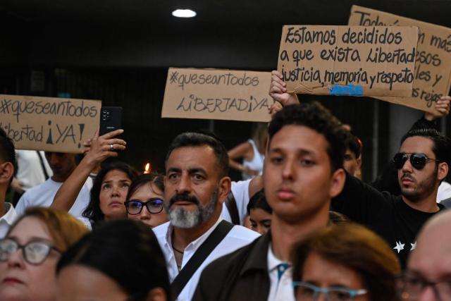 Relatives of political prisoners hold sings during a vigil in Caracas on May 22, 2026. Venezuela's interim president, Delcy Rodrнguez, said on May 22 that the release of political prisoners will exceed 500 “in the coming hours,” as she announced during an official broadcast. (Photo by Maryorin Mendez / AFP)