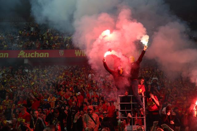 Lens RC supporters celebrate as they greet the victorious players after Lens RC won the French Cup final football match against Nice OGC in Lens, northern France, on May 22, 2026. (Photo by FRANCK FIFE / AFP)