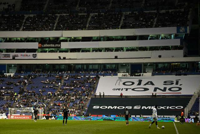 A giant banner that reads in Spanish: "The Wave YES, Shout NO," is seen on the benches during the friendly football match between Mexico and Ghana at the Cuauhtemoc Stadium in Puebla, Mexico, on May 22, 2026. The Mexican Football Federation (FMF) announced on May 22 that it had been sanctioned by FIFA for homophobic chants heard during the Mexican national team’s matches against Ecuador and Paraguay in October and November 2025. (Photo by Alfredo ESTRELLA / AFP)