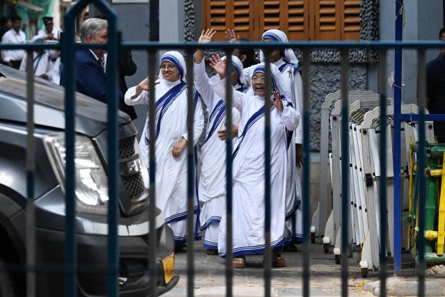 Sisters of the Missionaries of Charity wave to US Secretary of State Marco Rubio after his visit to the international headquarters of Missionaries of Charity known as the "Mother House" in Kolkata on May 23, 2023. (Photo by Dibyangshu SARKAR / AFP)