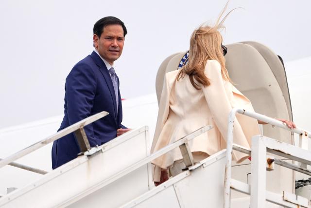 US Secretary of State Marco Rubio and his wife Jeanette board their plane for New Delhi at Netaji Subhash Chandra Bose International Airport in Kolkata on May 23, 2026. Rubio arrived May 23 on his first trip to India where he will meet Prime Minister Narendra Modi on the heels of US diplomacy with China. (Photo by Julia Demaree Nikhinson / POOL / AFP)