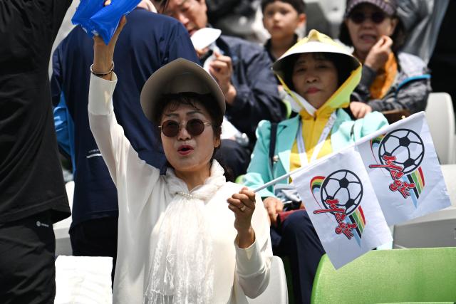 South Korean supporters for North Korea's Naegohyang Women's FC cheer up prior to the AFC Women's Champions League final football match between North Korea's Naegohyang Women's FC and Japan's Tokyo Verdy Beleza in Suwon on May 23, 2026. (Photo by JUNG YEON-JE / AFP)