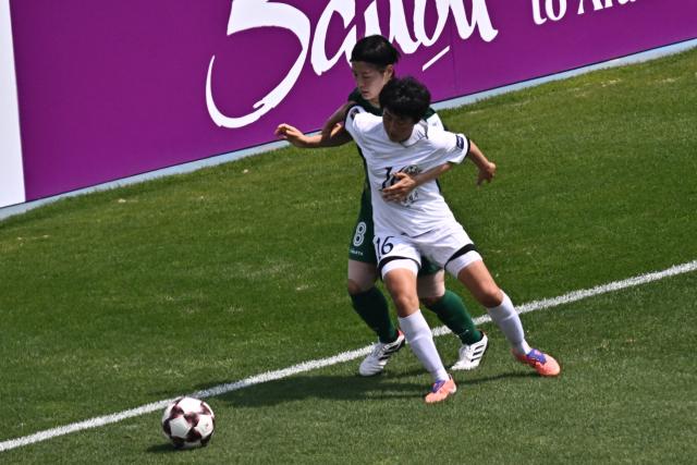 North Korea's Naegohyang Women's FC defender Ri Yu Jong (R) vies for the ball with Japan's Tokyo Verdy Beleza midfielder Hikaru Naomoto during the AFC Women's Champions League final football match between North Korea's Naegohyang Women's FC and Japan's Tokyo Verdy Beleza at Suwon Sports Complex in Suwon on May 23, 2026. (Photo by Pedro Pardo / AFP)