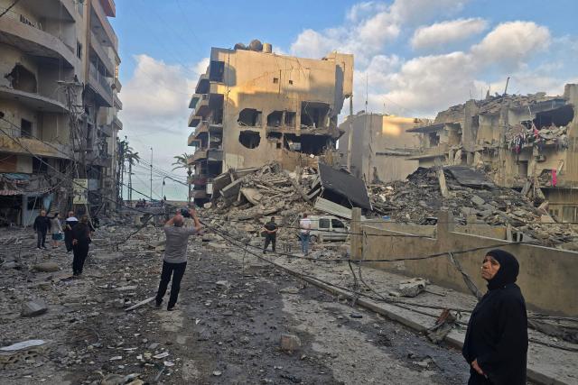 People inspect the site of an Israeli strike in the southern Lebanese coastal city of Tyre on May 23, 2026. Two buildings in and around Tyre were struck overnight on May 22 into May 23, after the Israeli military issued an evacuation warning. (Photo by KAWNAT HAJU / AFP)