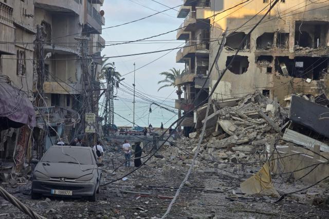 People inspect the site of an Israeli strike in the southern Lebanese coastal city of Tyre on May 23, 2026. Two buildings in and around Tyre were struck overnight on May 22 into May 23, after the Israeli military issued an evacuation warning. (Photo by KAWNAT HAJU / AFP)