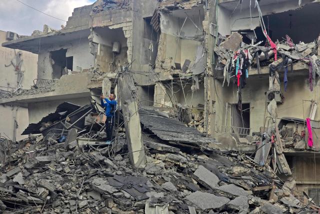 A man looks for his belongings amid debris of a destroyed building at the site of an Israeli strike in the southern Lebanese coastal city of Tyre on May 23, 2026. Two buildings in and around Tyre were struck overnight on May 22 into May 23, after the Israeli military issued an evacuation warning. (Photo by KAWNAT HAJU / AFP)