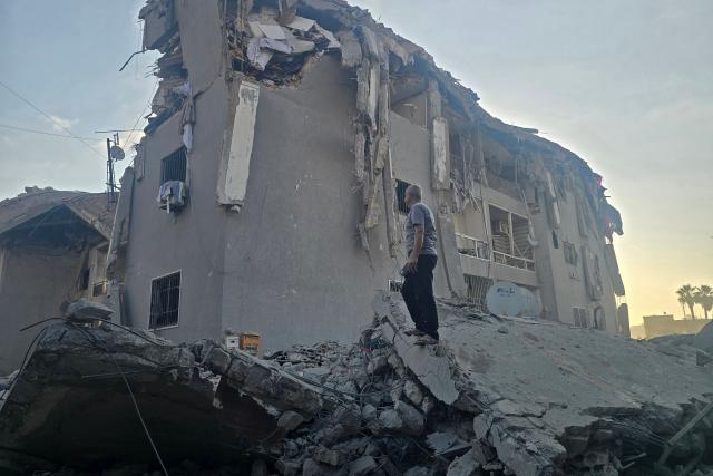 A man looks for his belongings amid debris of a destroyed building at the site of an Israeli strike in the southern Lebanese coastal city of Tyre on May 23, 2026. Two buildings in and around Tyre were struck overnight on May 22 into May 23, after the Israeli military issued an evacuation warning. (Photo by KAWNAT HAJU / AFP)