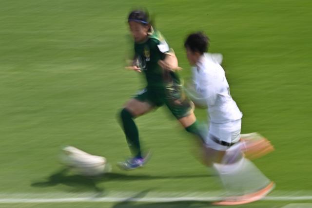 North Korea's Naegohyang Women's FC defender Ri Yu Jong (R) vies for the ball with Japan's Tokyo Verdy Beleza defender Yuna Aoki during the AFC Women's Champions League final football match between North Korea's Naegohyang Women's FC and Japan's Tokyo Verdy Beleza at Suwon Sports Complex in Suwon on May 23, 2026. (Photo by Pedro Pardo / AFP)