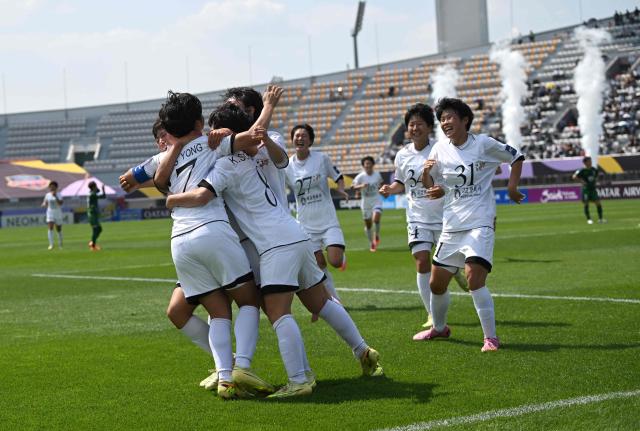 Kim Kyong Yong (L #17) of Naegohyang Women's FC celebrates scoring her team's first goal with teammates during the AFC Women's Champions League final football match between North Korea's Naegohyang Women's FC and Japan's Tokyo Verdy Beleza in Suwon on May 23, 2026. (Photo by JUNG YEON-JE / AFP)