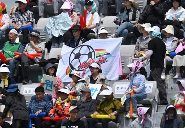 A South Korean supporter for North Korea's Naegohyang Women's FC waves a flag of Naegohyang team during the AFC Women's Champions League final football match between North Korea's Naegohyang Women's FC and Japan's Tokyo Verdy Beleza in Suwon on May 23, 2026. (Photo by JUNG YEON-JE / AFP)